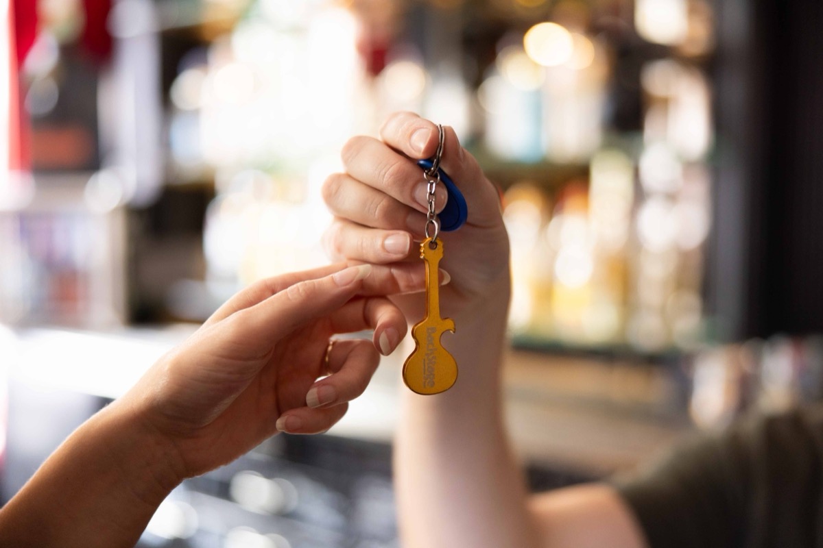 A Backstage Hotel guitar keyfob handed across the bar